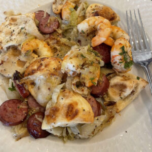 sausage cabbage pierogi plated with shrimp